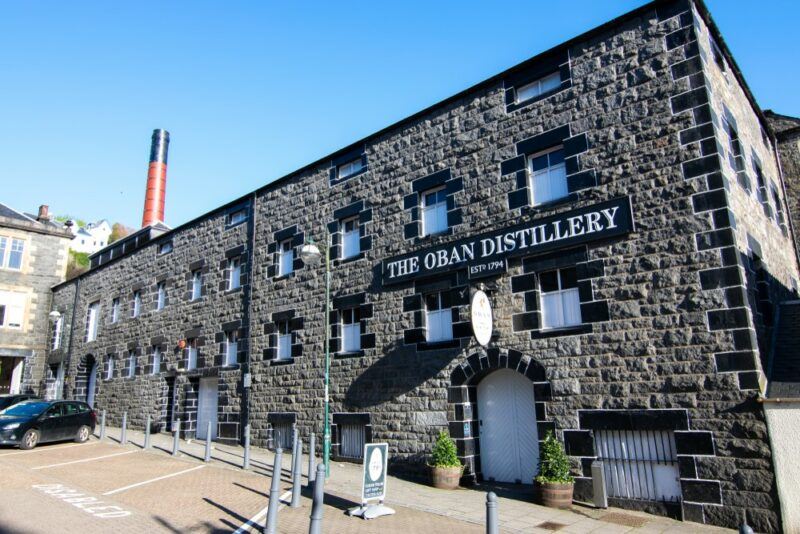 A dark brick building with the Oban Distillery written on it