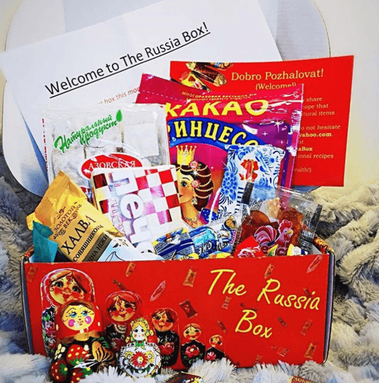 A red box with various Russian snacks and dolls