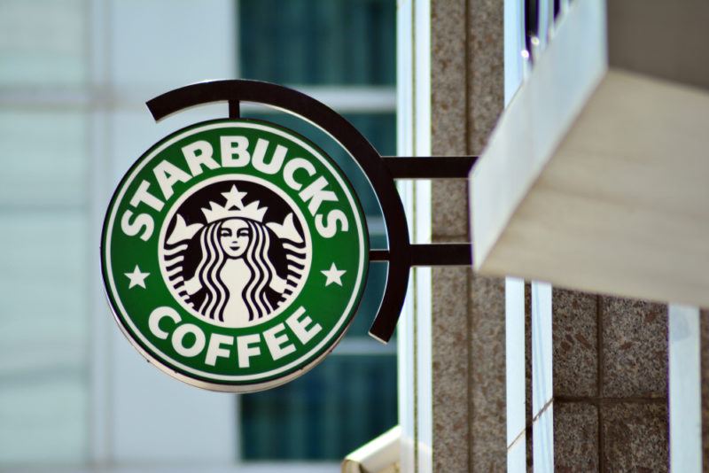 The green and white Starbucks logo outside a Starbucks coffee shop