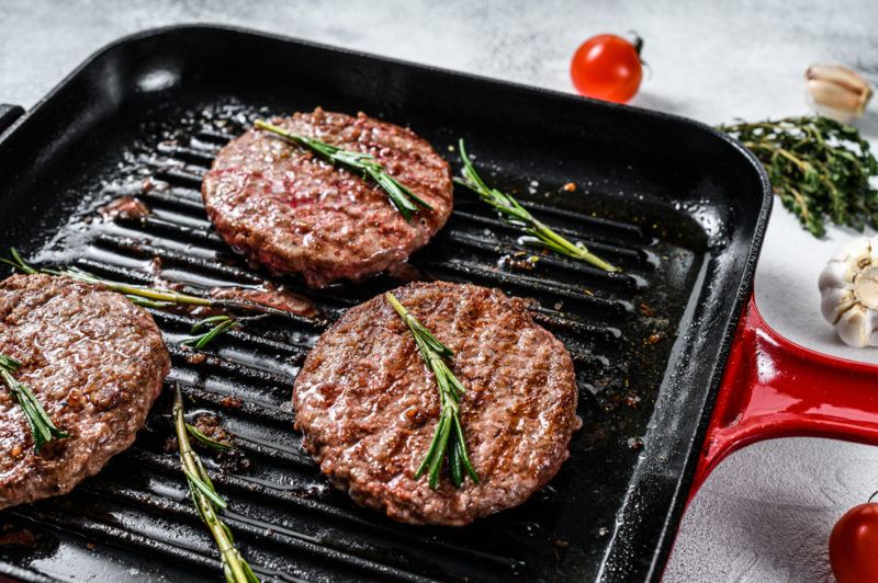 Three burger patties in a frypan | Food For Net Three burger patties on a grill