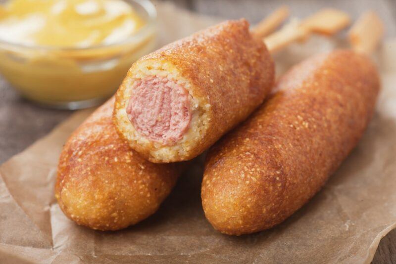 Three American corn dogs, with one stacked on top of the other two