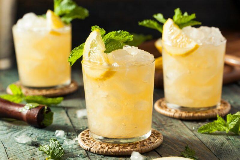 Three glasses of a lemon beat cocktail on coasters with plenty of ice