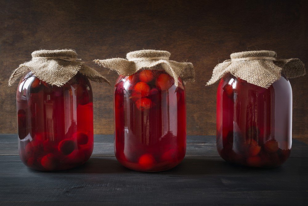 Three jars of kompot with fruit, with cloth lids