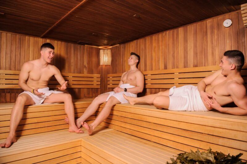 Three men wearing towels relaxing in a spa or a sauna