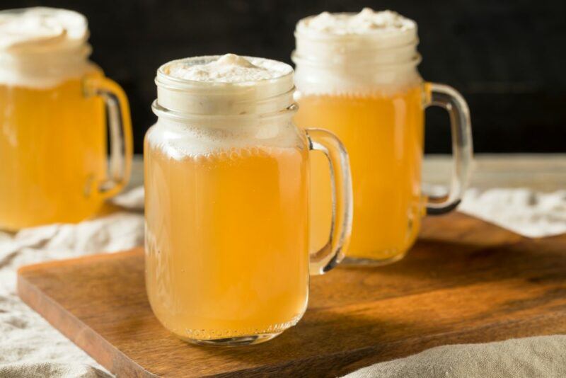 Three mugs of butterbeer cocktail, with a creamy topping