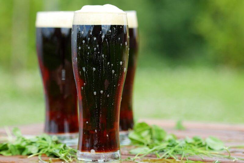 Three tall glasses containing root beer or a cocktail called everbeer