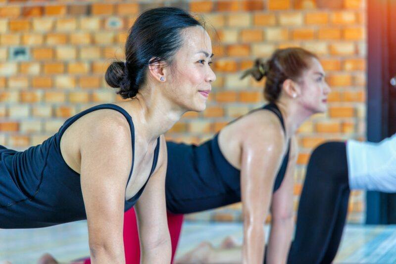 Three women in a yoga studio doing hot yoga