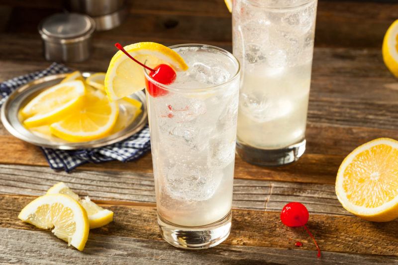 Two Tom Collins cocktails with lemons and glace cherries