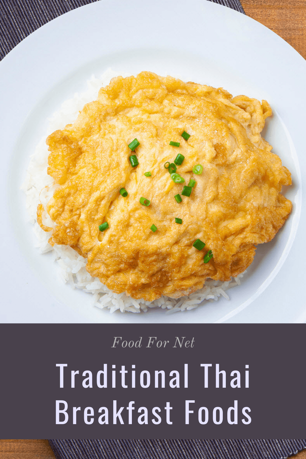 A crispy Thai omelet on a white plate on top of rice