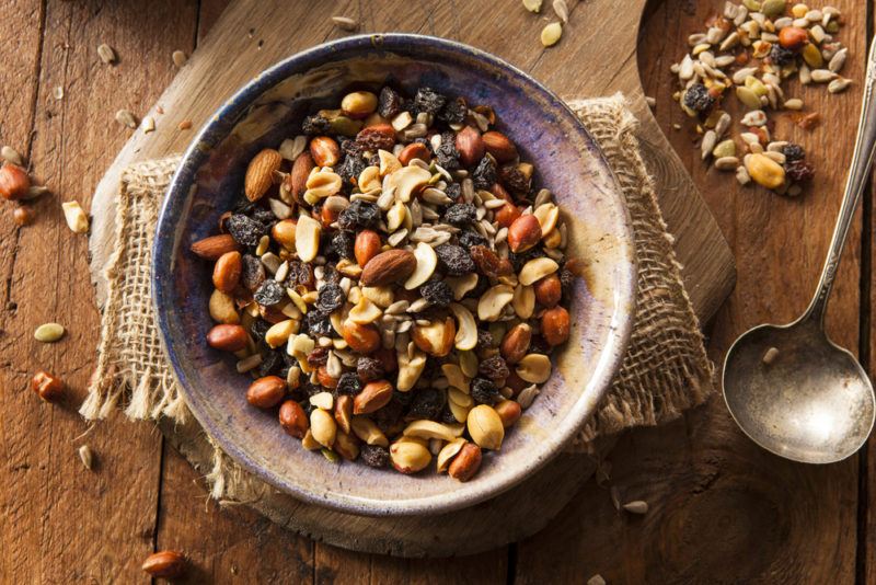 A board containing trail mix with seeds and nuts.