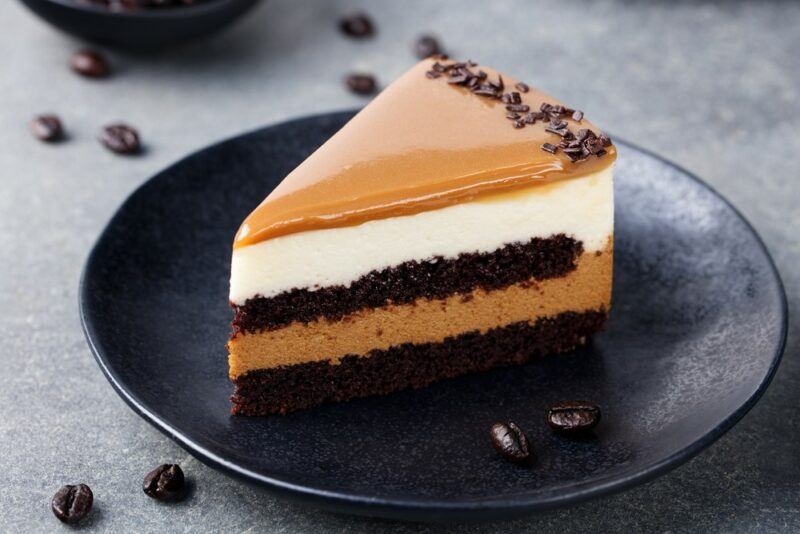 A small black plate with a layered chocolate mousse cake