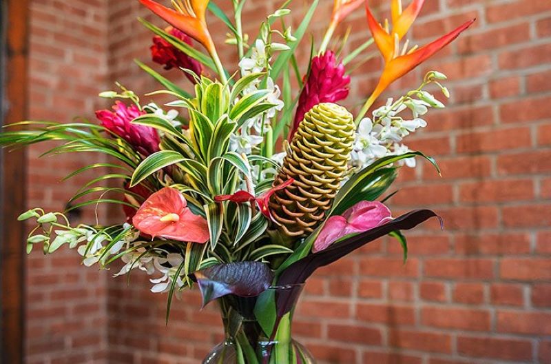 bright colored Tropical flower bouquet in clear glass vase