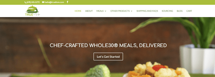True-Fare-website-screenshot | Food For Net True Fare website screenshot showing wan image of a dinner on a table, along with a pot plant in the background.