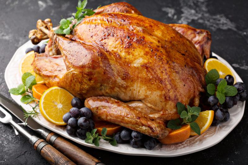 A white plate with a roast turkey and veggies