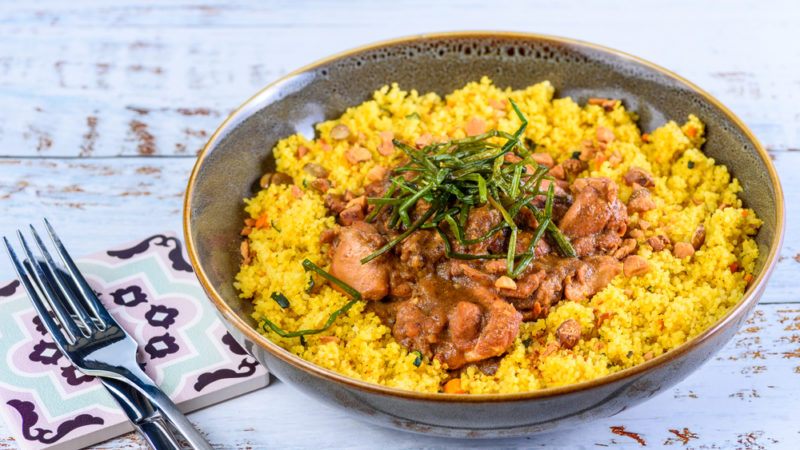 A pan of couscous that has had turmeric stirred through it