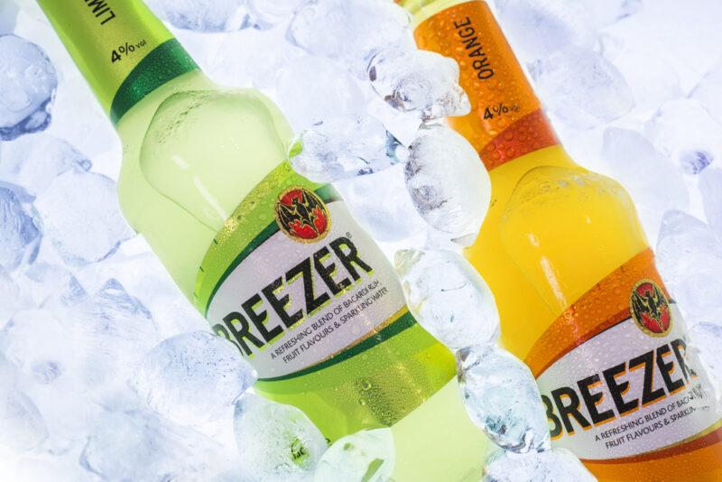 A pile of ice containing a green and an orange Bacardi Breezer