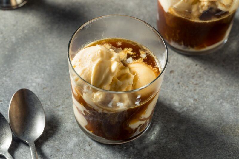 Two glasses containing Fireball float cocktails next to spoons