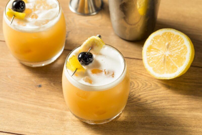 A wooden table with two amaretto sour cocktails