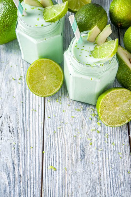 Two green avocado cocktails garnished with avocado