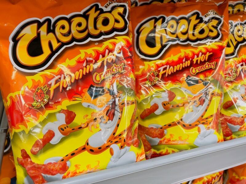 Bags of Flaming Hot Cheetos on a shelf, with a tiger on the logo