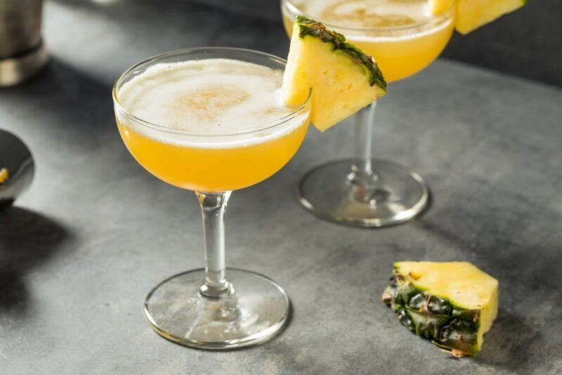 Two glasses containing barracuda cocktails on a gray table