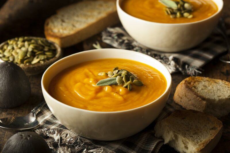 Two white bowls of butternut soup