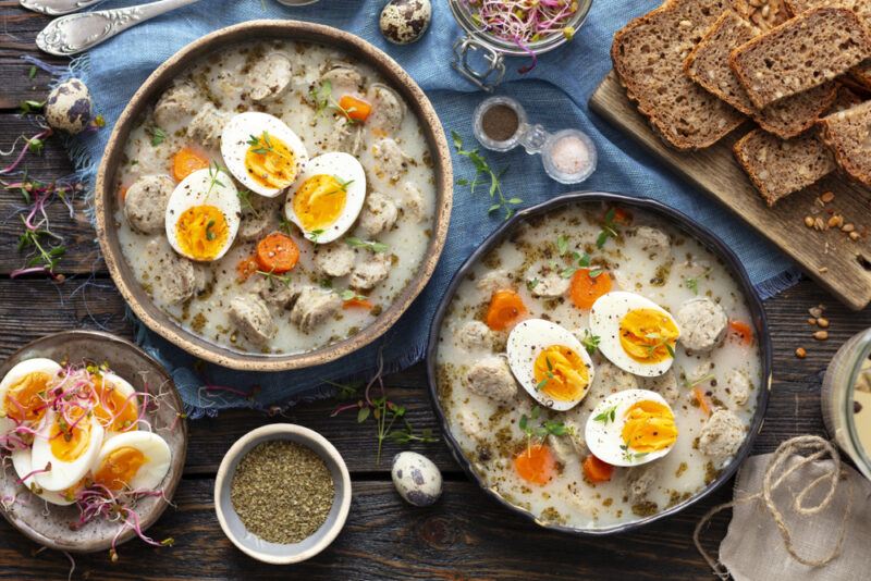 Two bowls of a Polish soup called zurek with boiled eggs on top