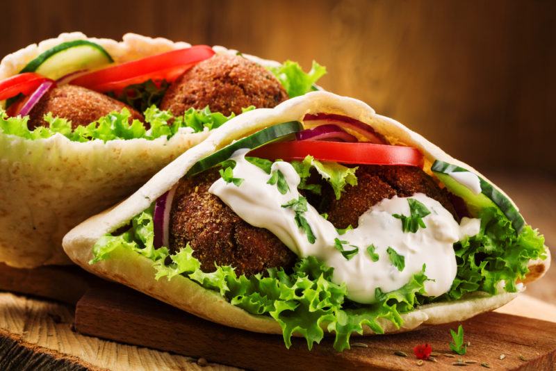 Two falafel sandwiches with lettuce, tomato, and sauce