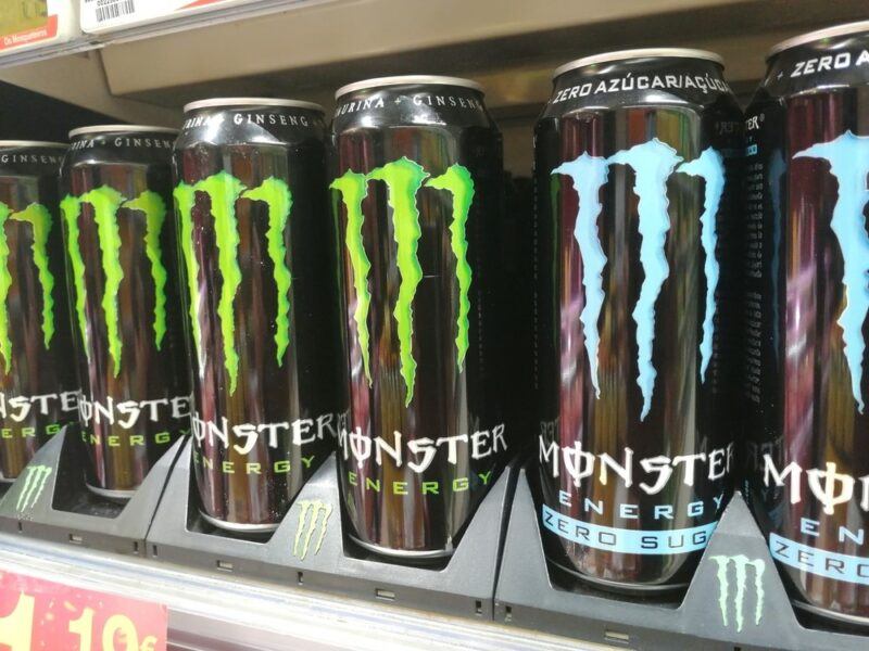 A grocery store shelf with two types of Monster energy drink