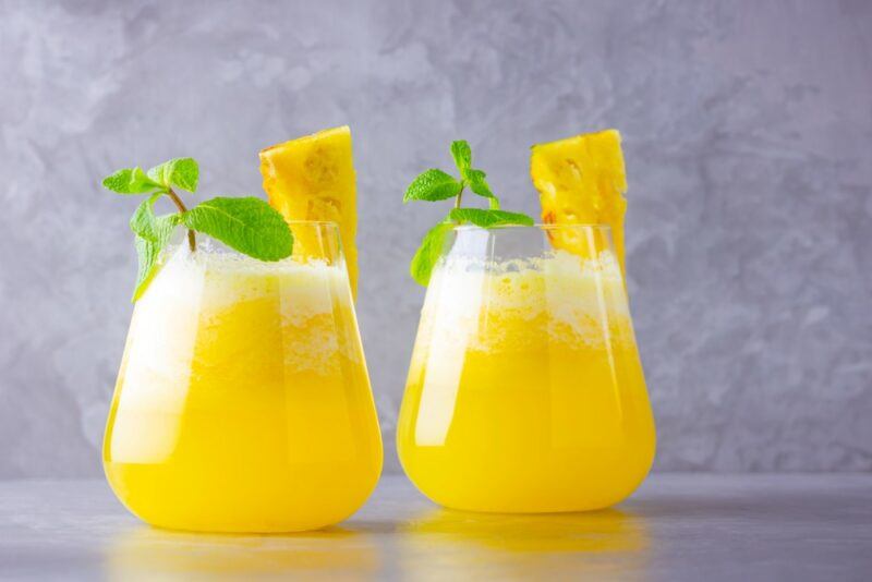 Two glasses containing pineapple fog cutter cocktails