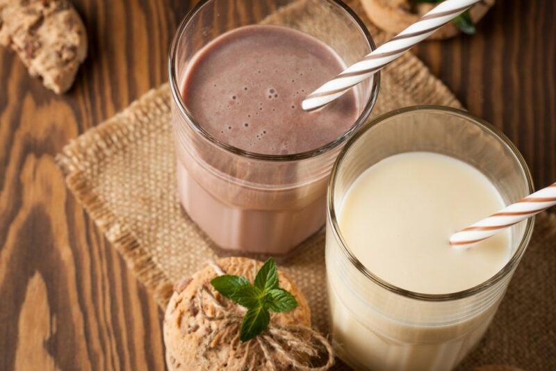 Two glasses containing protein shakes, one chocolate, one vanilla