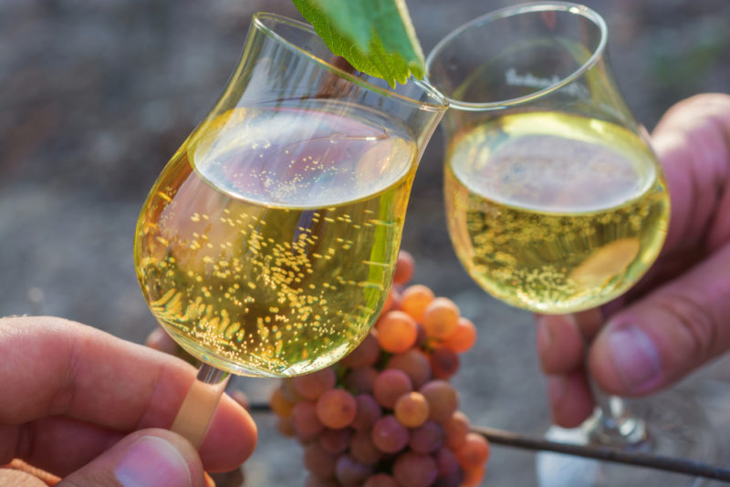 Two people toasting with glasses of Gewürztraminer