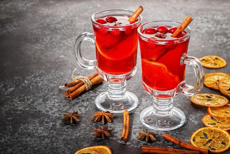 Two cranberry hot toddies with fresh berries and cinnamon sticks