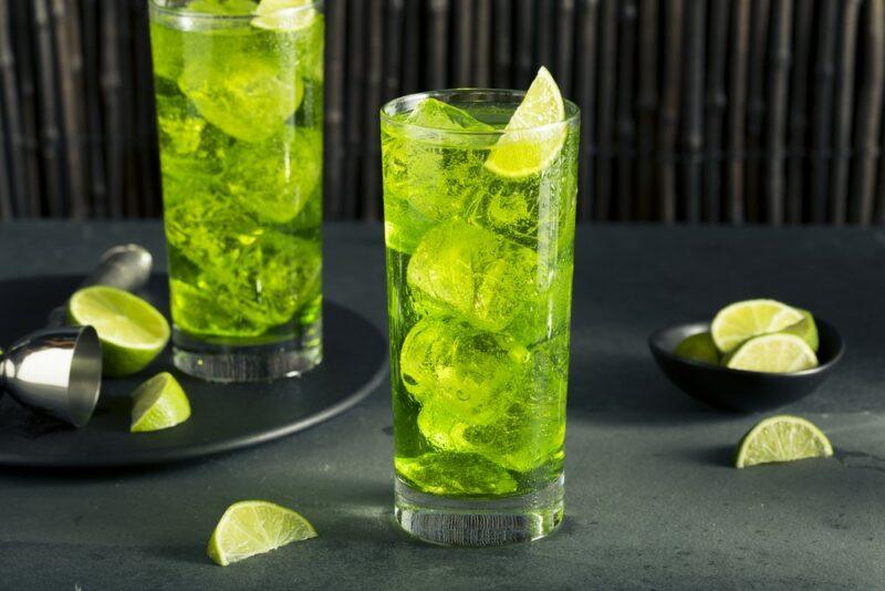 Two glasses of a bright green cocktail called the toxic tonic