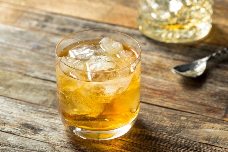 Two glasses of a honey whiskey Godfather cocktail on a wooden table