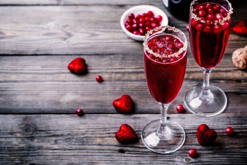 Two glasses containing a cranberry mimosa or poinsettia cocktail