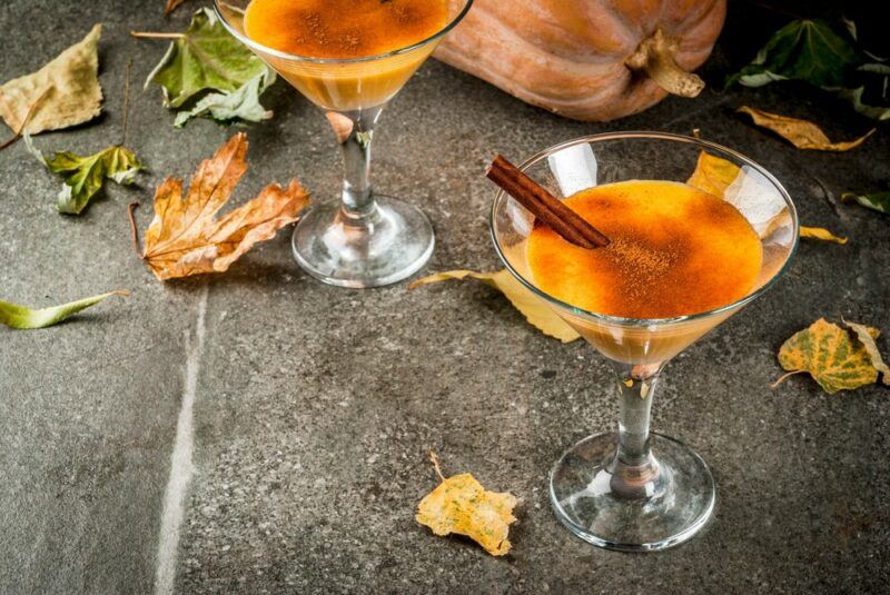 Two glasses of a pumpkin pie cocktail on a wooden table