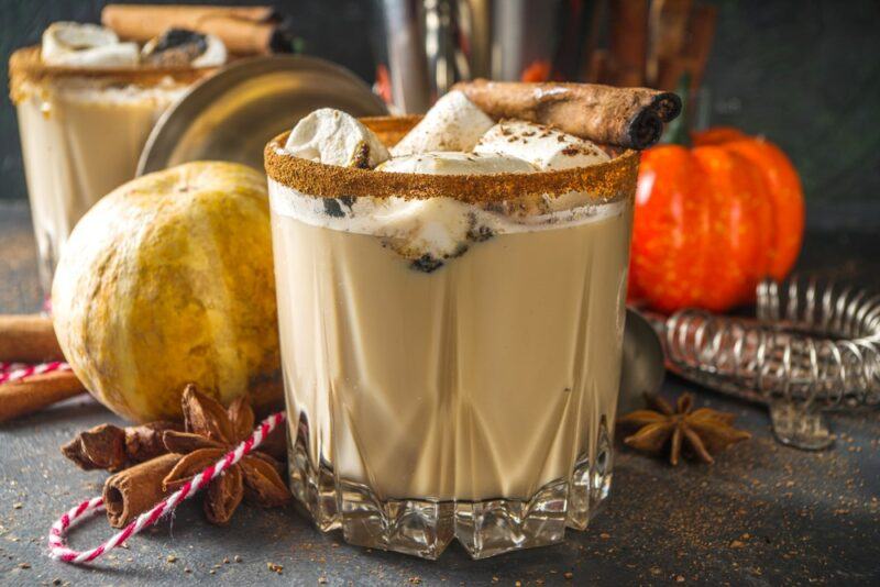 Two glasses of a pumpkin spice white Russian cocktail, where there is a graham crust rim on the glass