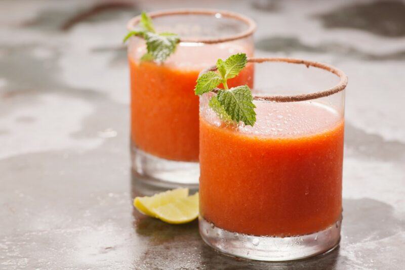 Two glasses of a red sun cocktail on a table