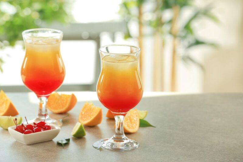 Two glasses of a tequila sunrise mimosa cocktail on a kitchen counter