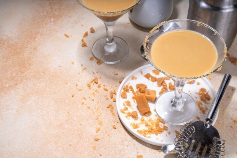 Two martini glasses on a table containing a tres leches martini