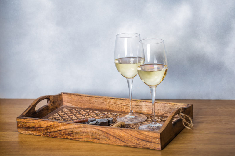 Two glasses of chardonnay on a wooden tray