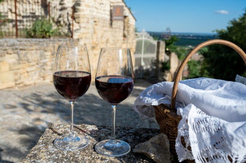 Two glasses of grenache wine in Italy or somewhere similar, next to a picnic basket