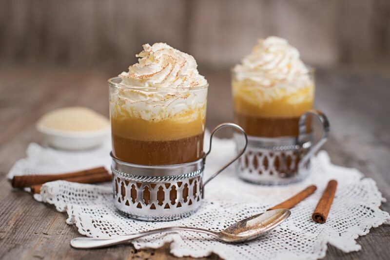 Two glasses of hot buttered rum, with whipped cream on top