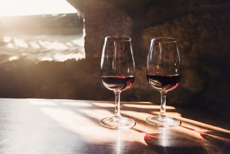 Two glasses of port in an underground room with sunlight streaming in from a window