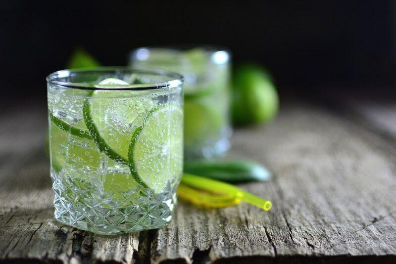 Two glasses of sparkling water with lime slices on a wooden table