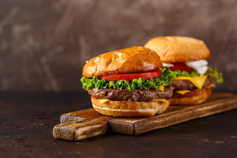 Two hamburgers on a wooden board