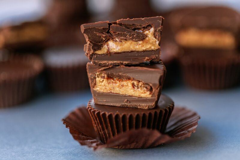 Homemade peanut butter cups in a stack with more peanut butter cups in the background