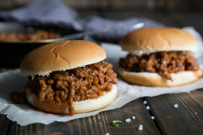 Two sloppy joes made using burger buns on a table