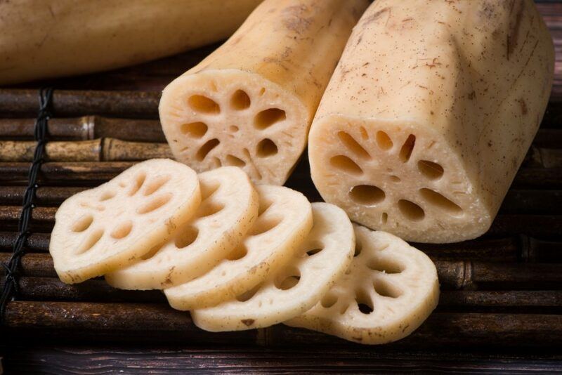 Two white lotus roots that have been sliced to clearly show the interior structure